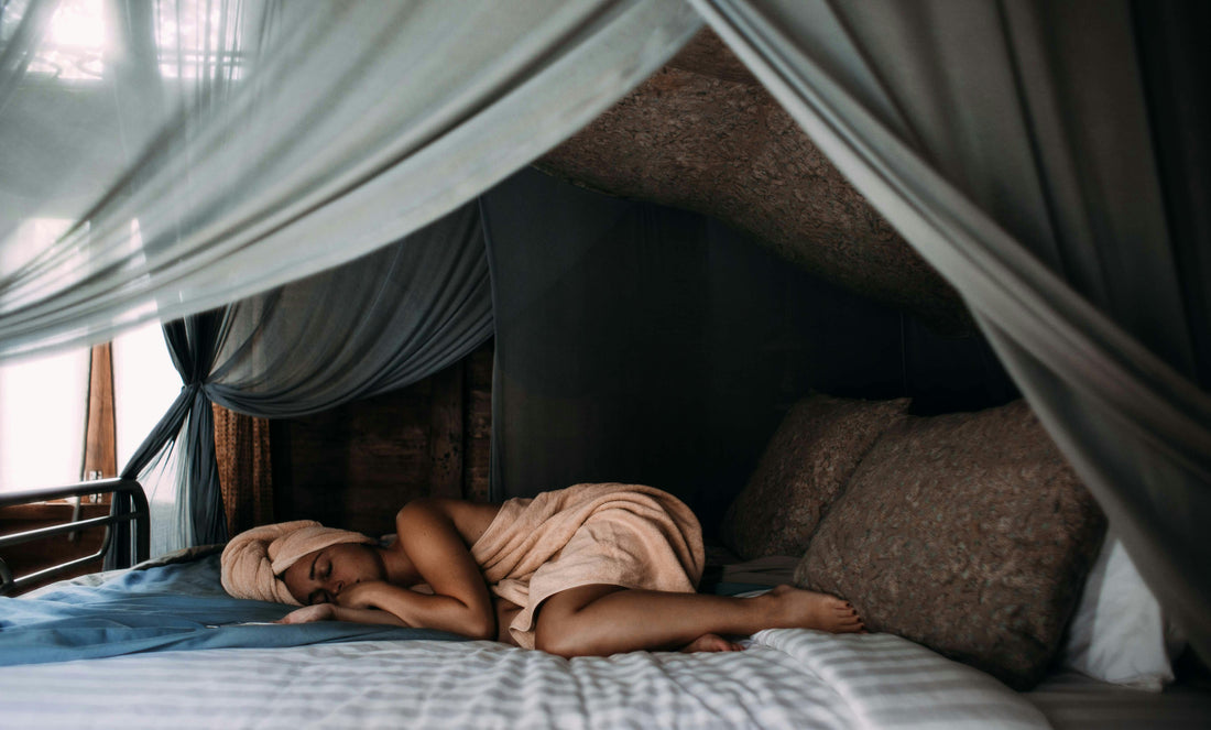 woman sleeping on bed wrapped in towel